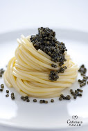 Spaghetti au Caviar Ingrédients pour 4 personnes 200 g de spaghetti de Gragnano étirés au bronze, une boîte de 50 g de Caviar frais Calvisius, 30 g de beurre, poivre noir, sel  Faites cuire les spaghetti dans environ deux litres d’eau salée en ébullition, mettez le beurre dans une terrine que vous placerez au-dessus de la casserole des pâtes pour le faire fondre. Tenez à part une louche d’eau de cuisson, égouttez les spaghetti et assaisonnez avec le beurre, une mouture de poivre et l’eau tenue à part. Mélangez, répartissez dans les assiettes, disposez dessus un peu de Caviar et servez immédiatement.